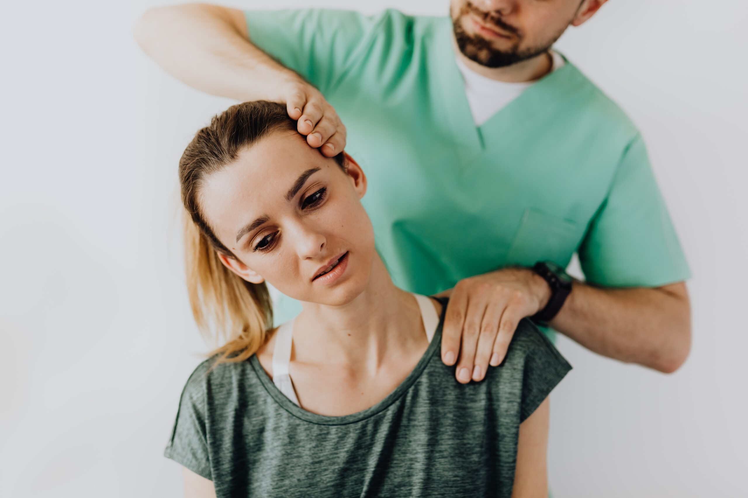 Physical therapist examining woman for whiplash neck injury after accident