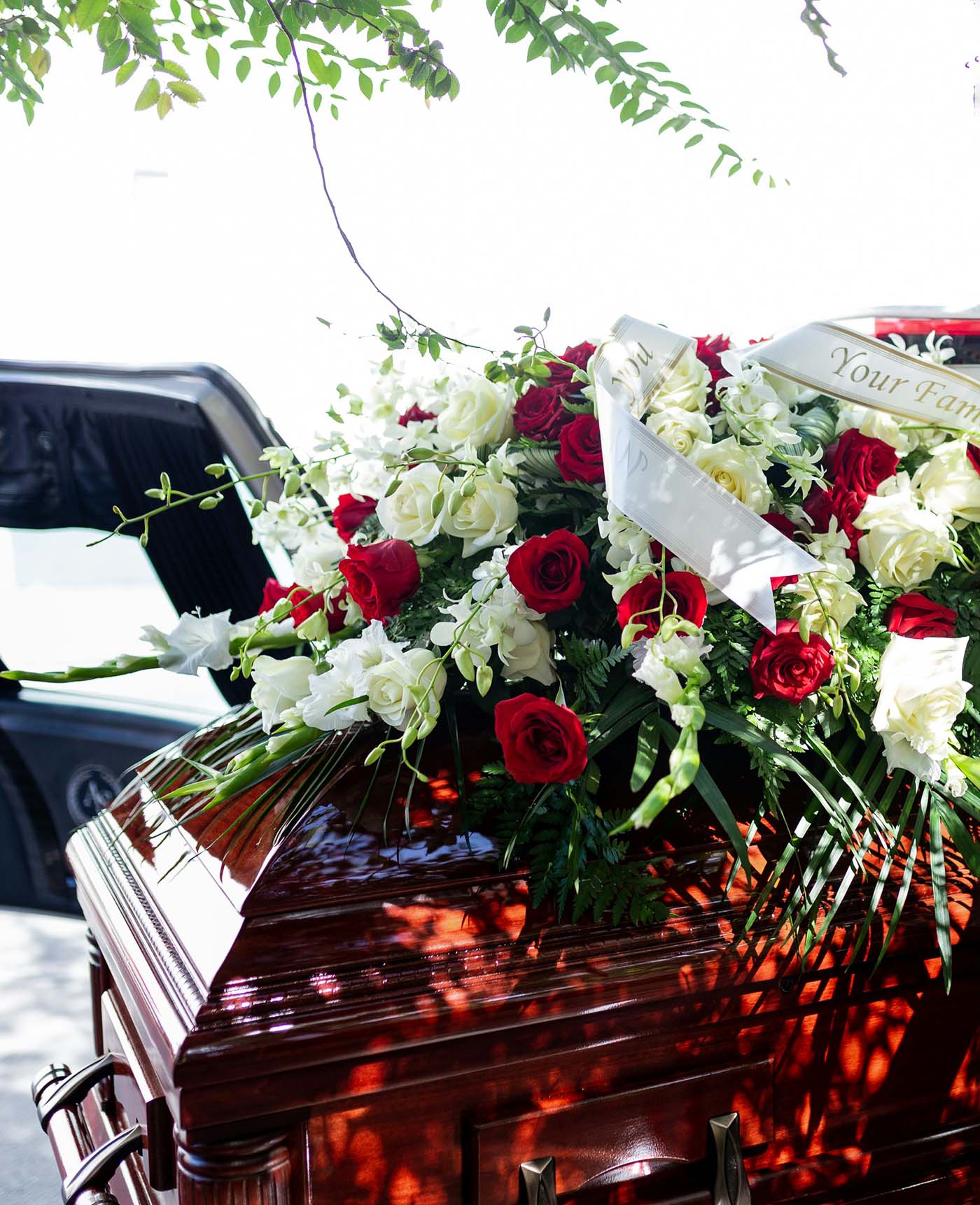 Wooden casket adorned with red and white roses, symbolizing a funeral after a wrongful death in Eugene, Oregon