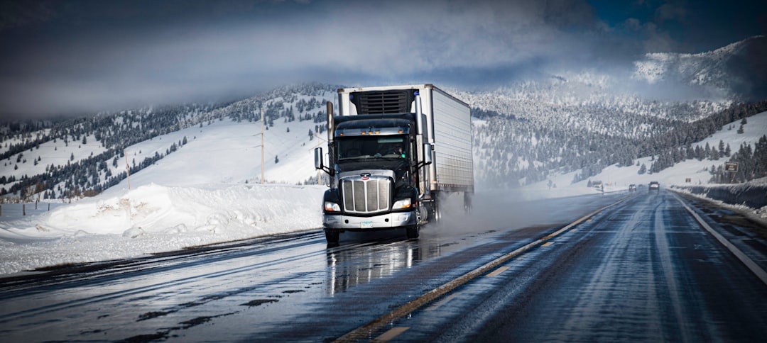 Semi-truck driving on a wet mountain highway in snowy Colorado conditions