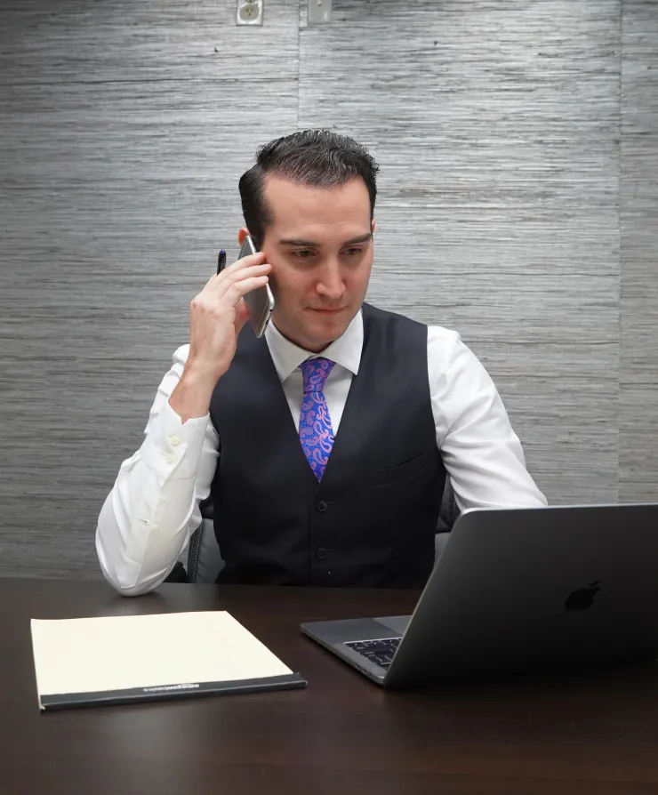 Strong Law attorney speaking by phone at an office desk